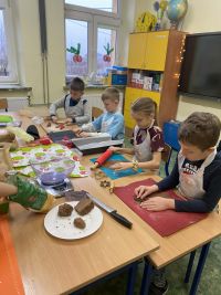 750d1216-8d2c-4a8a-b5ea-1eb8f365fcd0uczniowie ozdabiają pierniki